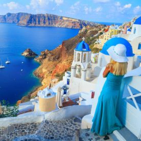 Discovering Greece.Beautiful blond woman enjoying vacations in Santorini, Greece. Looking at view.