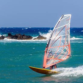 Monolythos, Santorini, Greece - August 25, 2015: Windsurfer making extreme tricks on a flat water at Santorini island, Greece