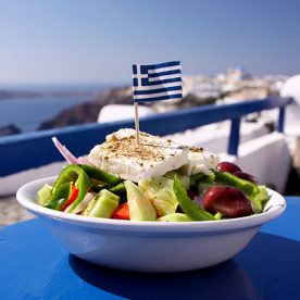 A perfect Greek salad, incorporating olives, green peppers and feta cheese, topped with a Greek flag, in Oia, Santorini