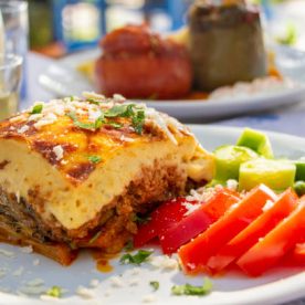 Greek traditional moussaka on a white plate served in taverna, Greece