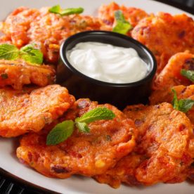 Tomatokeftedes Fried tomato balls a delicious greek ouzo meze from Santorini island close-up in a plate on the table. Horizontal